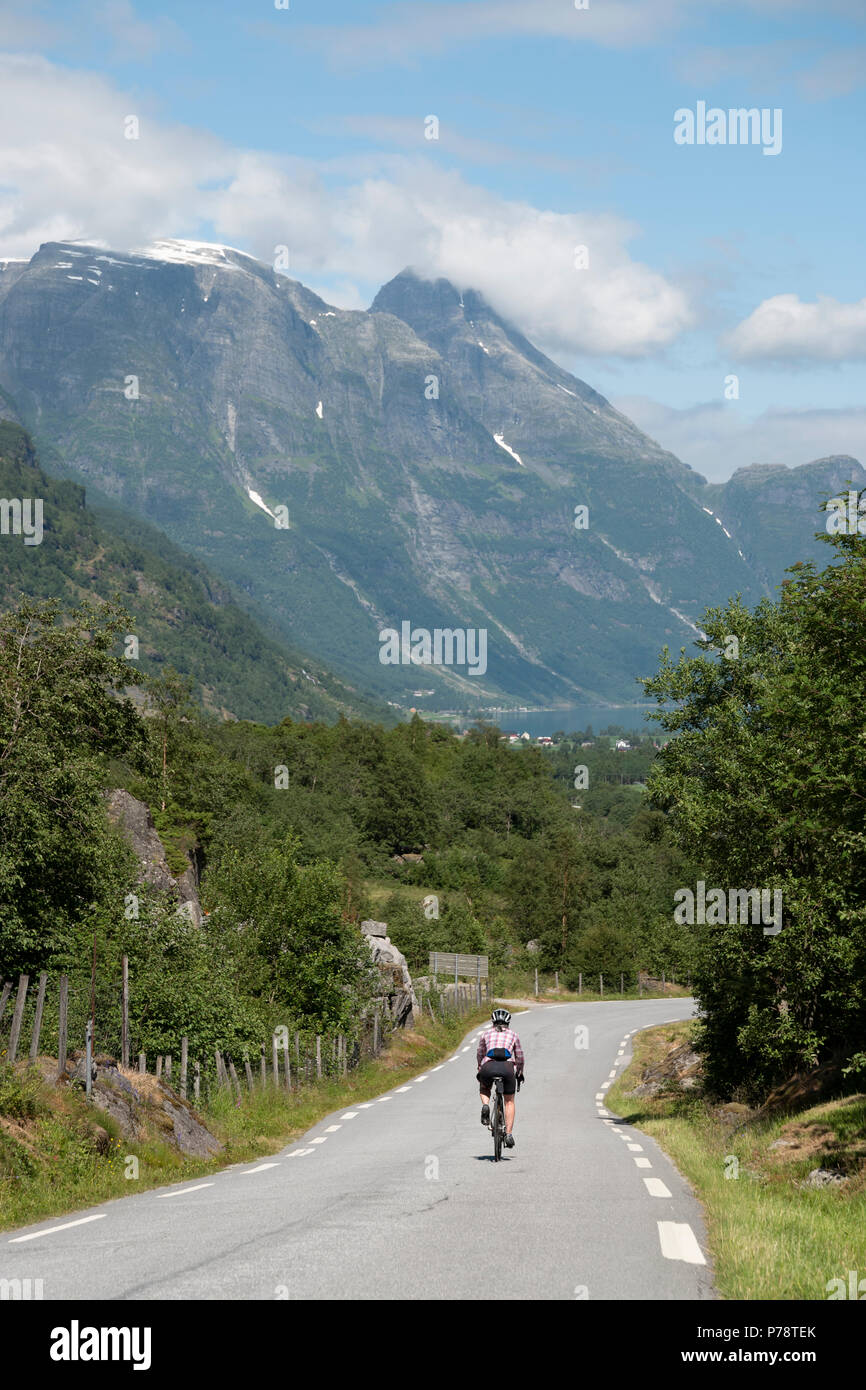 Weibliche Radfahrer auf der Valley Road über Olden, Norwegen Stockfoto