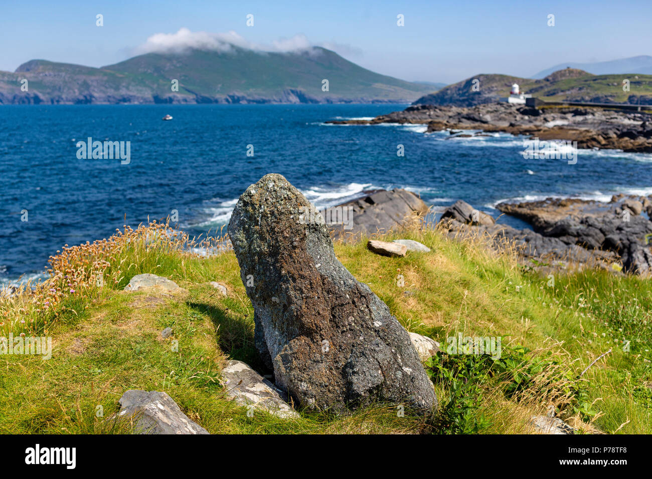 Kleine Standing Stone und Valentia Island Leuchtturm im Hintergrund, County Kerry, Irland Stockfoto