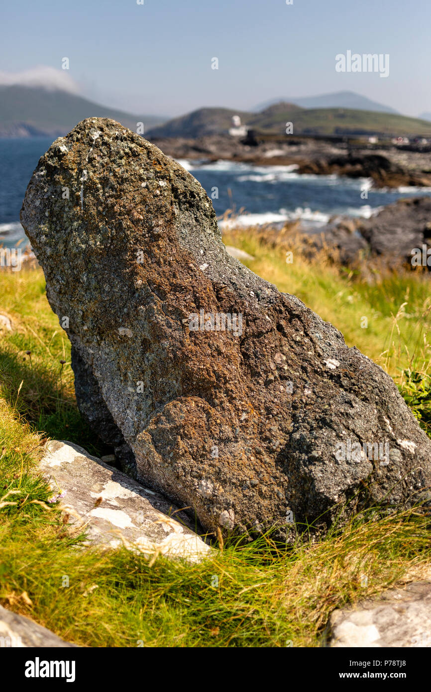 Kleine Standing Stone und Valentia Island Leuchtturm im Hintergrund, County Kerry, Irland Stockfoto