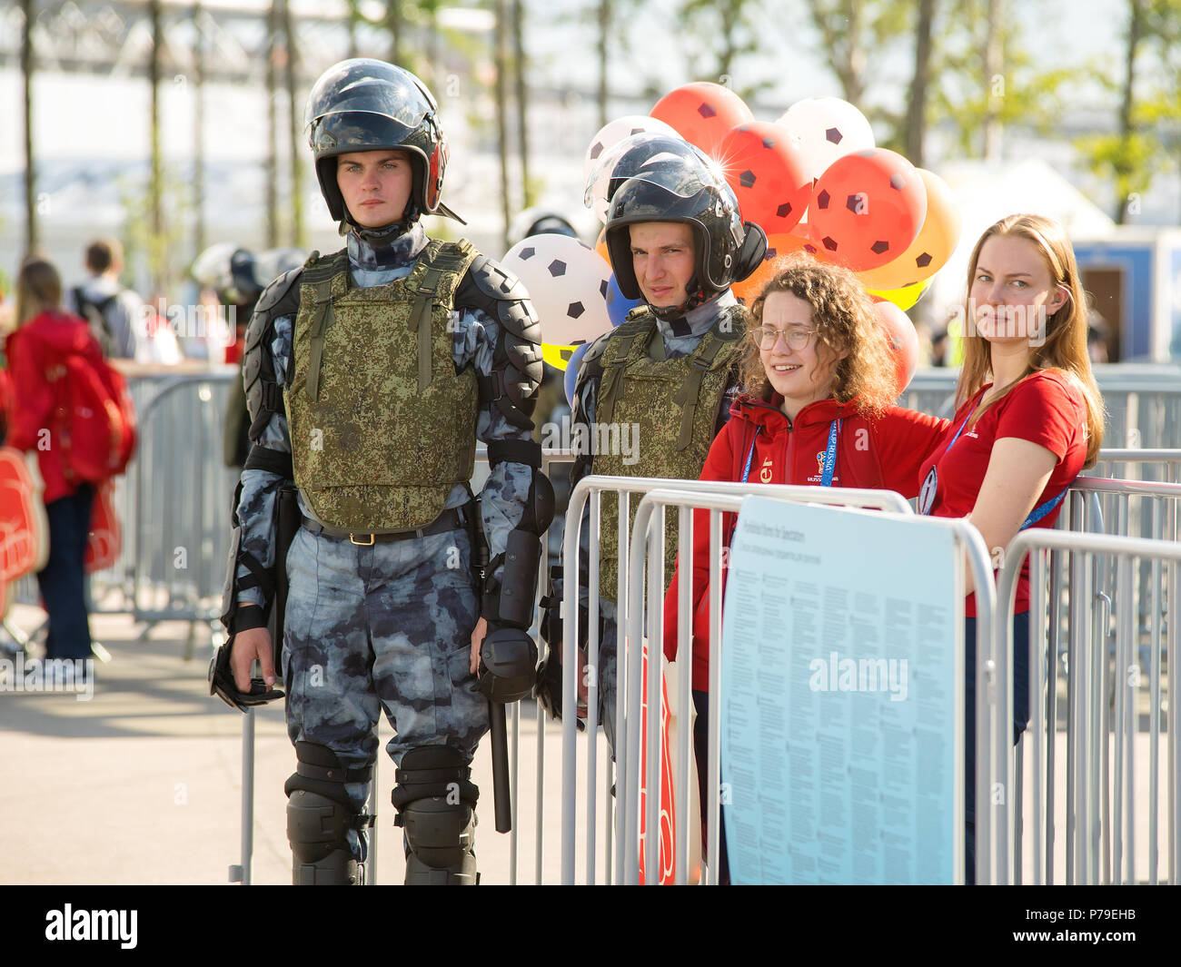 Sankt Petersburg. Russland - 03. Juli 2018. Schwere ausgestattete Polizei wachen und Freiwilliger am Eingang in FIFA WM Schweden - Schweiz auf Krest Stockfoto