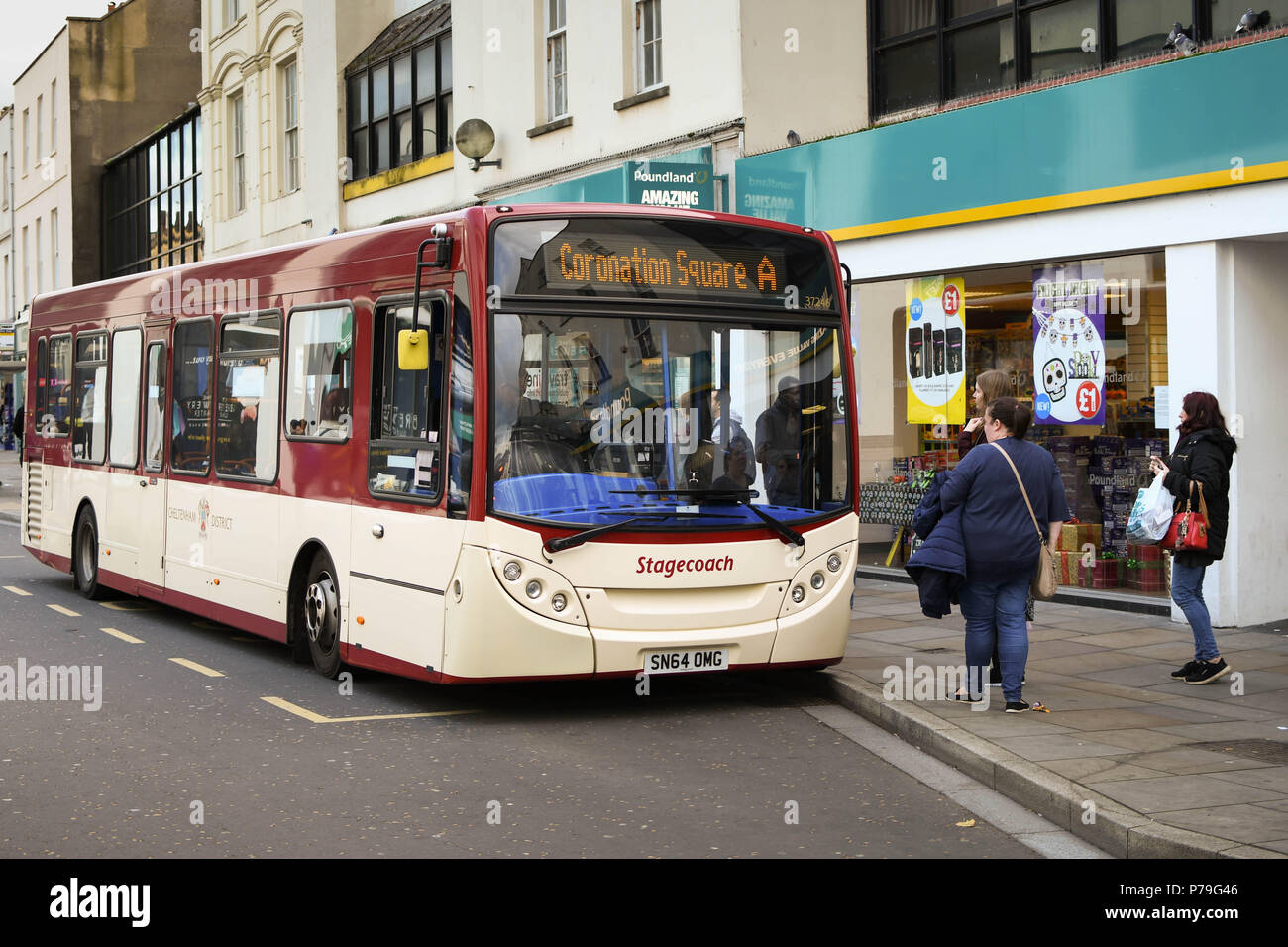 Menschen fangen einen öffentlichen Service Bus an einer Bushaltestelle in Cheltenham Town Centre Stockfoto