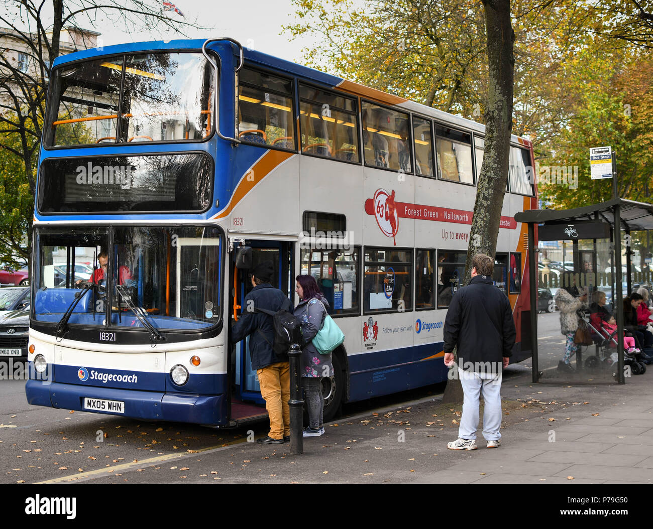 Menschen fangen einen öffentlichen Service Bus an einer Bushaltestelle in Cheltenham Town Centre Stockfoto