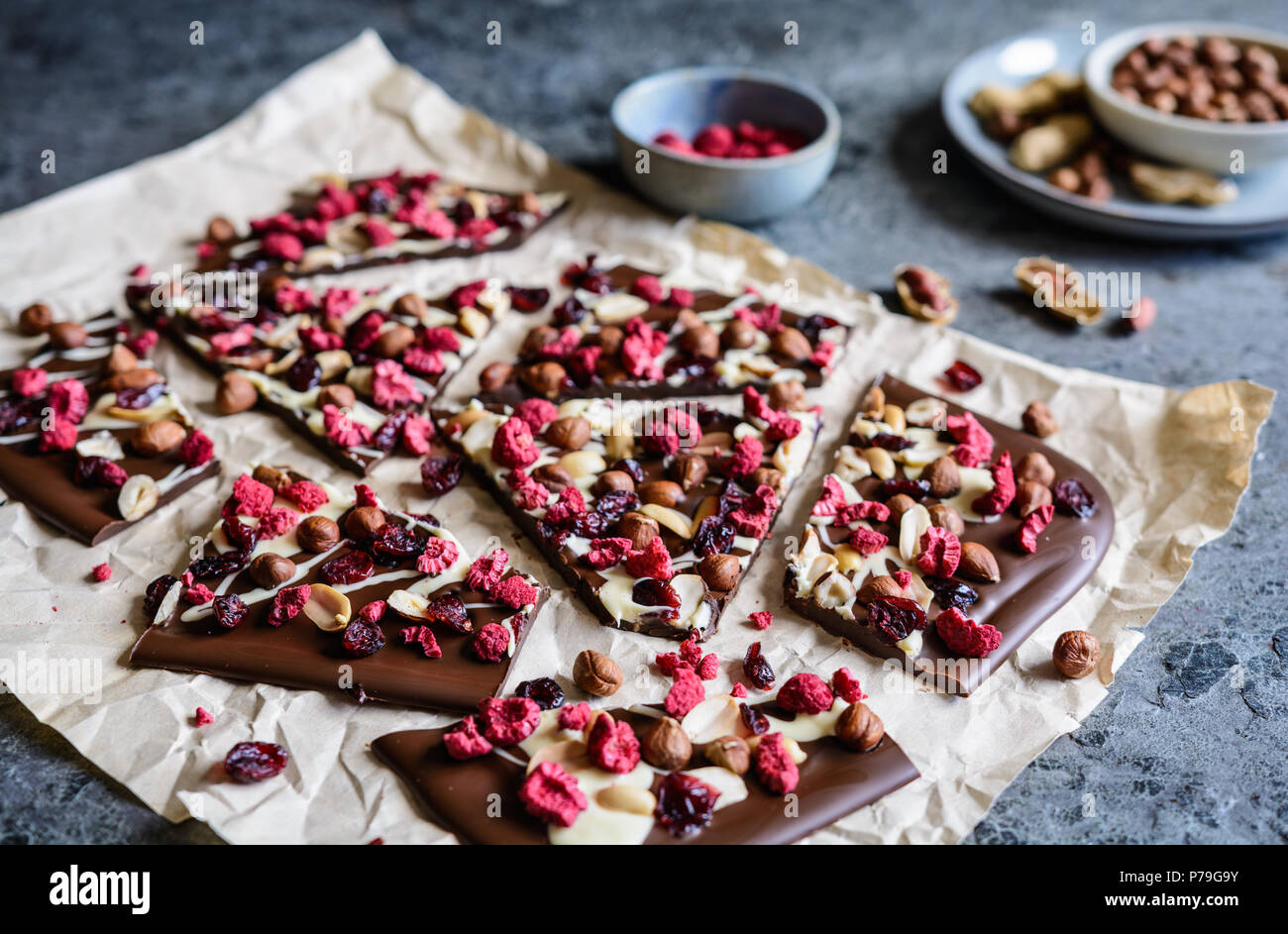 Hausgemachte Schokolade Rinde mit Haselnüssen, Erdnüsse, Preiselbeeren und Gefriergetrockneten Himbeeren Stockfoto