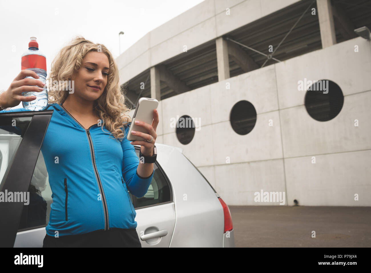 Schwangere Frau mit Handy in Parkplatz Stockfoto