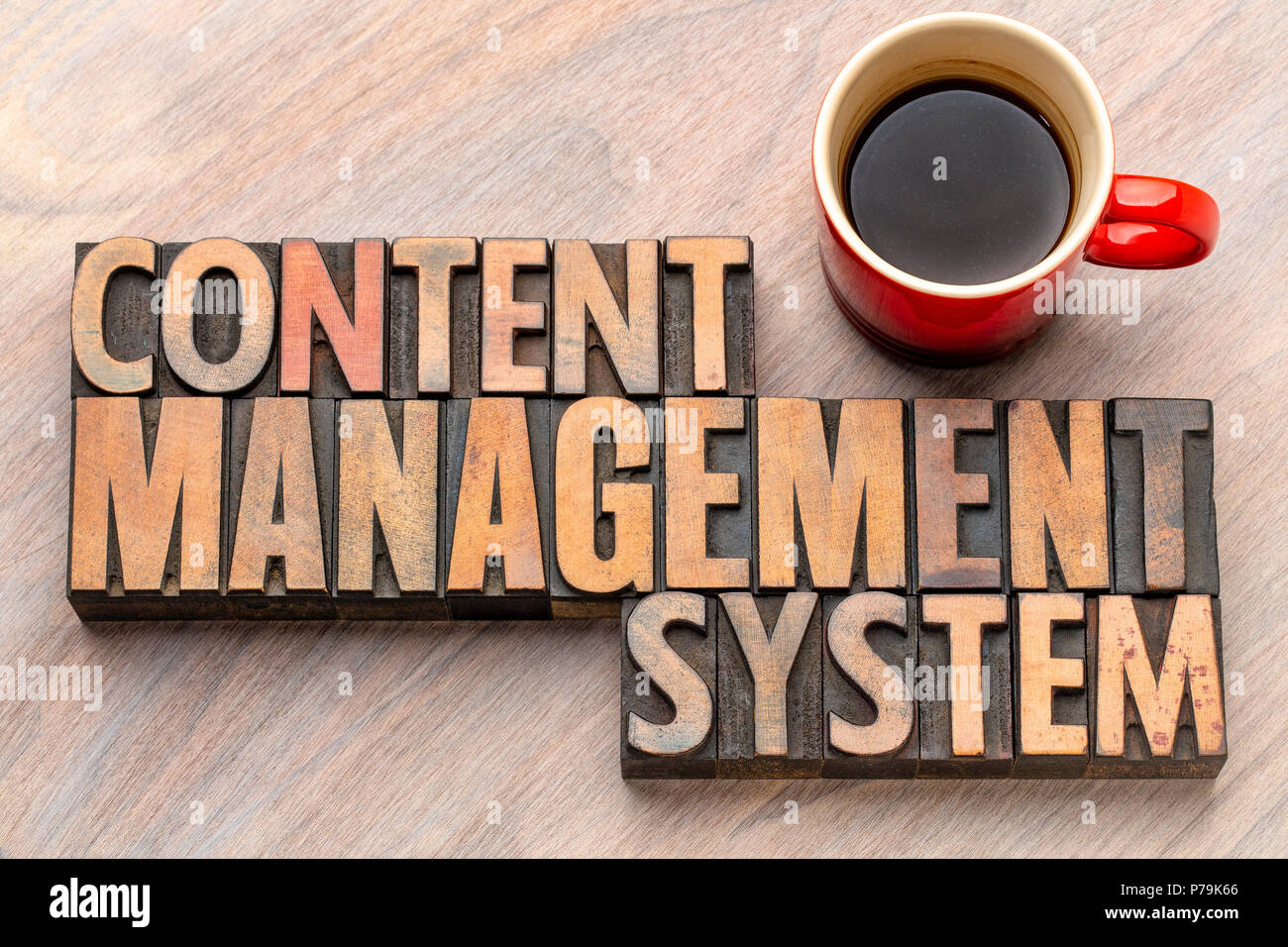 Content Management System - word Abstract in Vintage buchdruck Holz Blöcke mit einer Tasse Kaffee Stockfoto