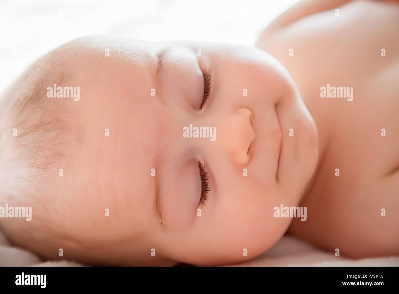 Ein Kleinkind junge bequem schlafen auf weißen Bett. Nahaufnahme Porträt einer schönen schlafenden Baby Boy. Neugeborene, Kindheit Thema. Textil- und Bettwäsche für Stockfoto