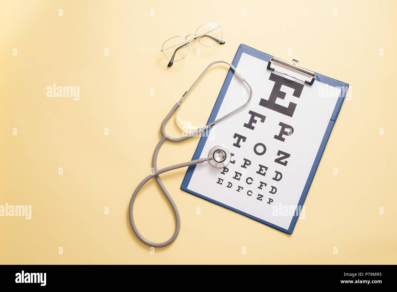 Tabelle für visual acuity Test und medizinische Stethoskop ist in gelben Hintergrund. Konzept der Auge Diagnose, Nachweis von Augenkrankheiten in der Ophthalmologie Stockfoto