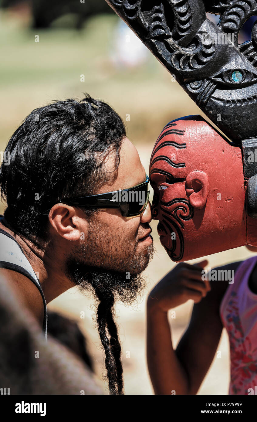 Maori Mann führt hongi mit der Vorderseite des Ngātokimatawhaorua zeremoniellen Krieg Kanu (Waka Taua) am Waitangi Treaty Grounds in Neuseeland Stockfoto