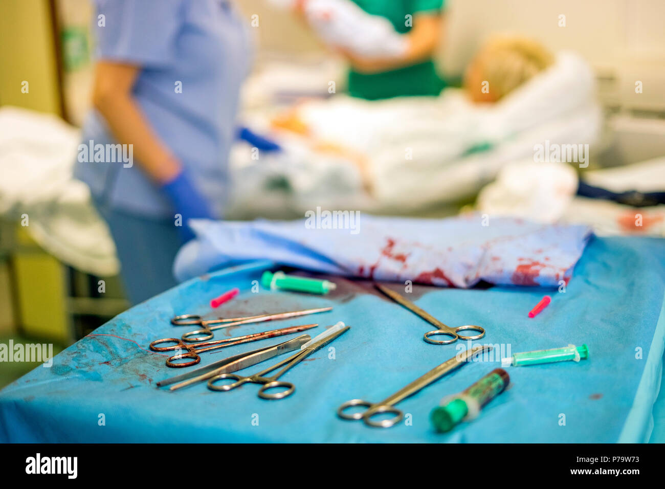 Silver Frauenarzt Werkzeuge während der Geburt und die Mutter und das Krankenhauspersonal im Hintergrund verwendet Stockfoto