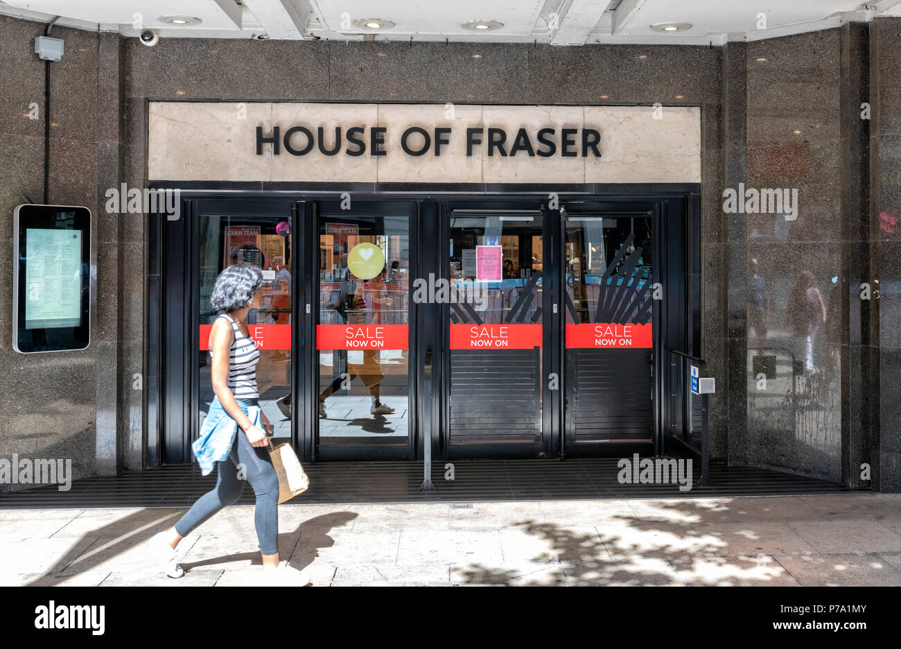 Eine Person, die Sie an einem House of Fraser Abteilung gespeichert mit Verkauf Zeichen in Manchester, UK geschmückt Stockfoto