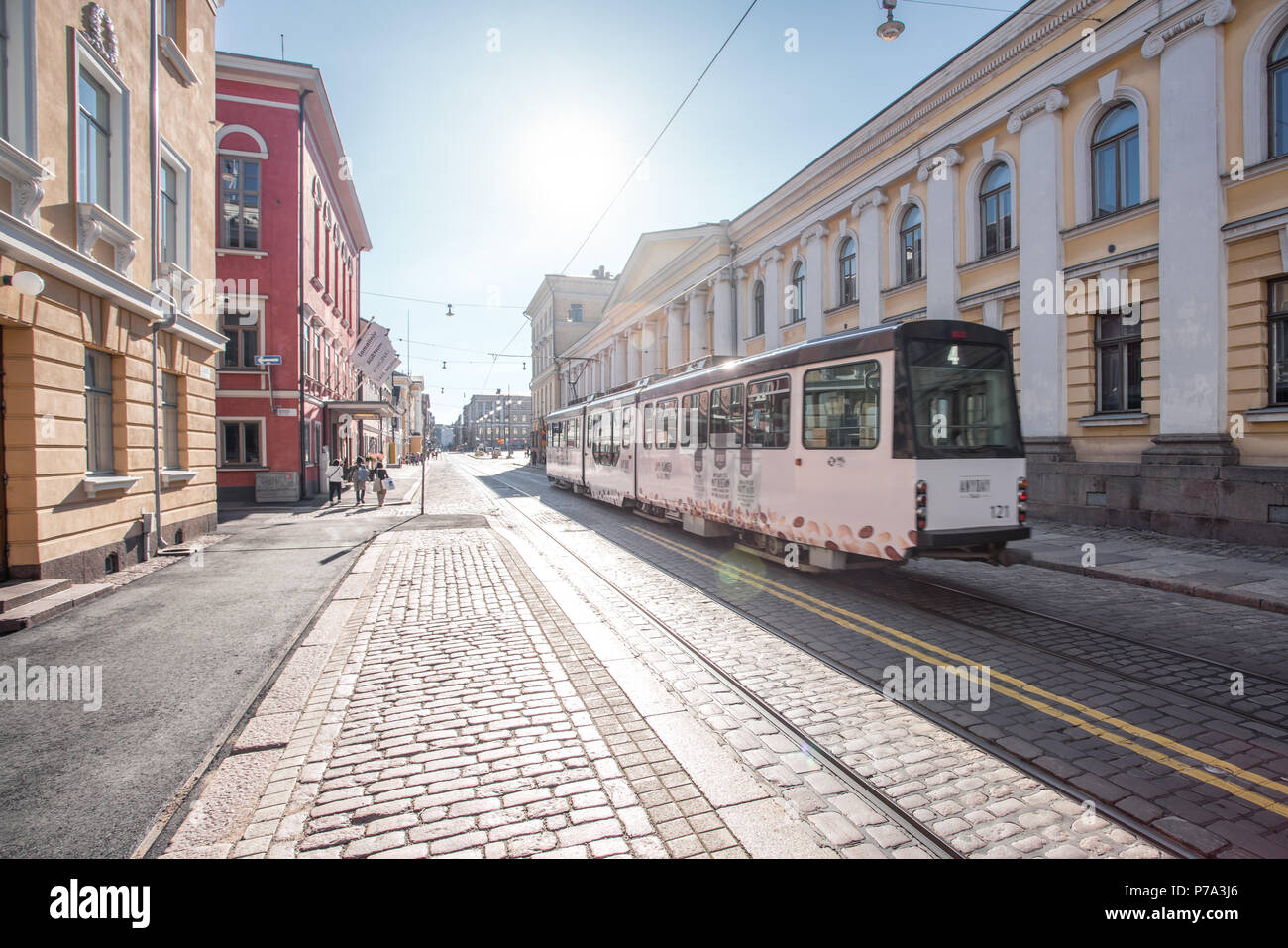 HELSINKI, FINNLAND - 25/6/2018: Straßenbahn auf gepflasterten Straßen von Helsinki gegen Sonnenlicht Stockfoto