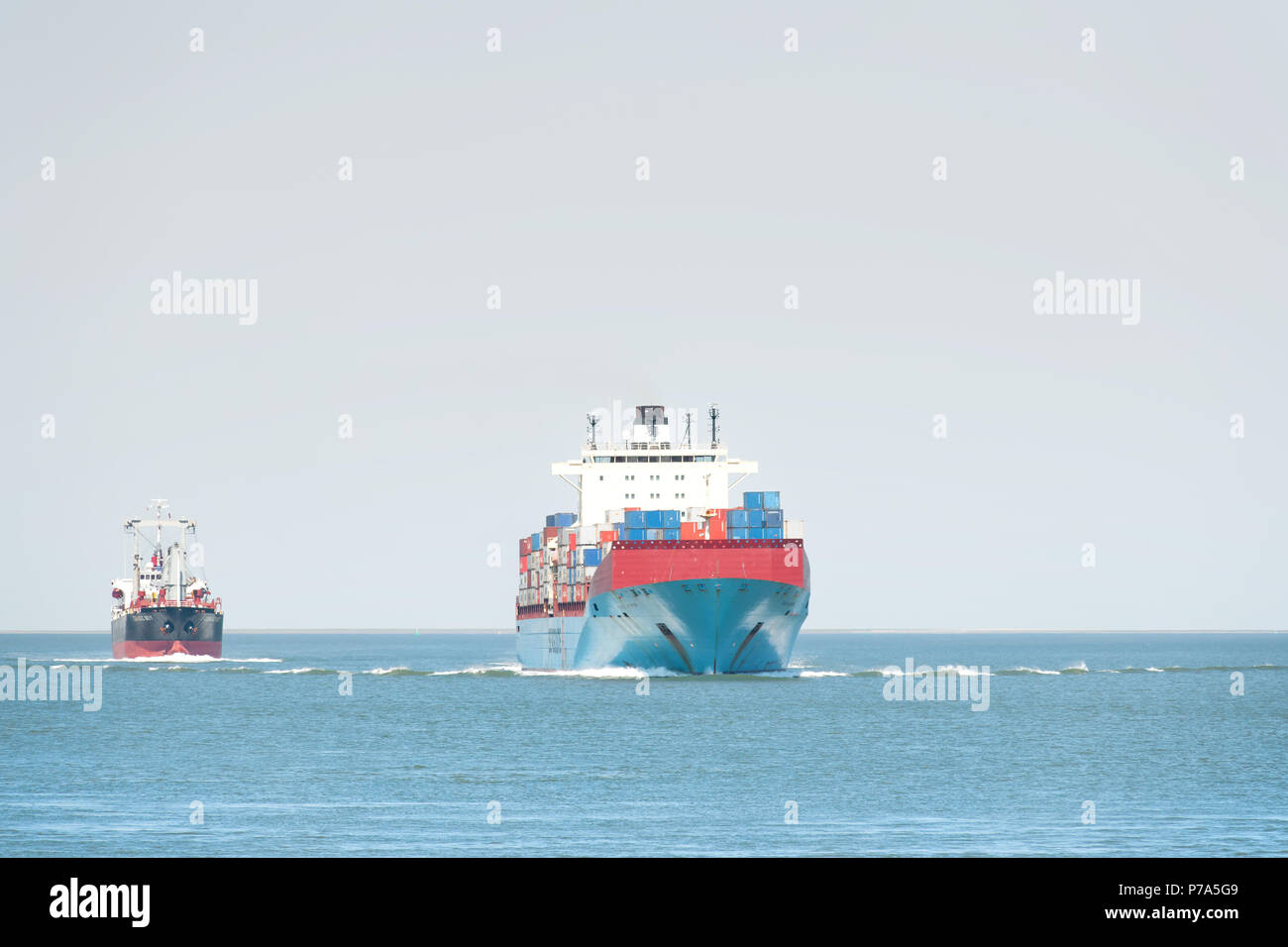 Ein Seeschiff führt ein kleines Boot auf der Westerschelde in der Nähe der Hafenstadt Terneuzen Zeeland Stockfoto