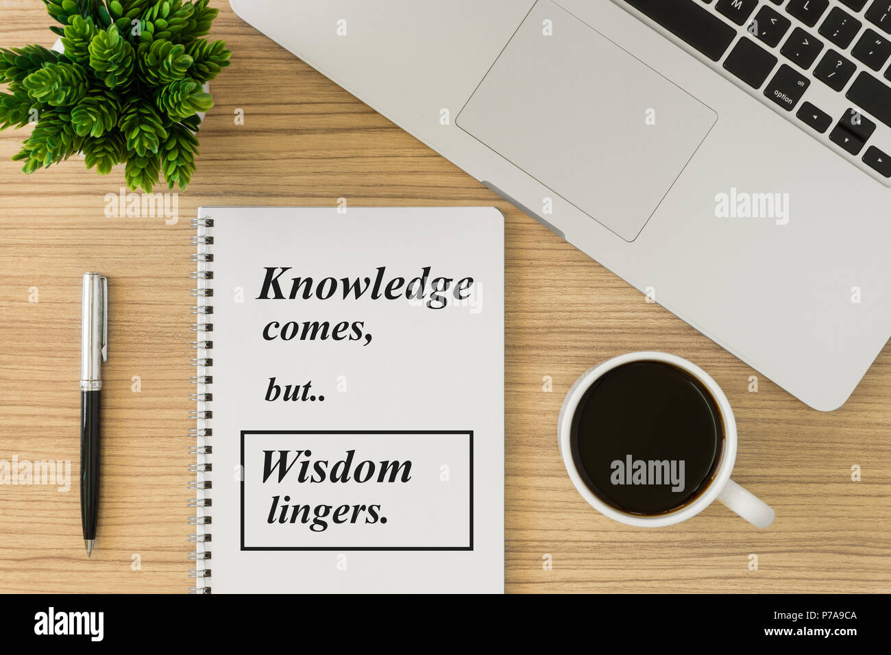 Notebook mit motivierende und inspirierende Weisheit Zitat auf Holz Schreibtisch. Wissen kommt aber Weisheit bleibt. Stockfoto