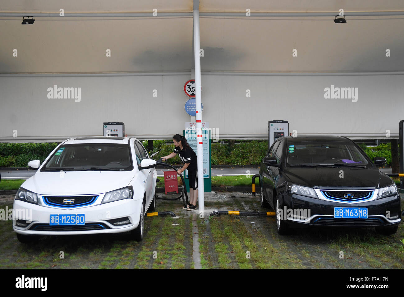 (180705) - Ningbo, Juli 5, 2018 (Xinhua) - eine Frau hat ihr Elektroauto in Tengtou Dorf Kanton Bezirk in Ningbo aufgeladen, im Osten der chinesischen Provinz Zhejiang, 4. Juli 2018. Mit einem Pro-Kopf-Einkommen von 63,500 Yuan (etwa 9,577 US-Dollar) im Jahr 2017, Tengtou wurde aus einem armen Dorf, ein Modell des guten Lebens entwickelt. Es hat sich eine 4-Schritt Entwicklungsplan durchgeführt werden seit 1965, einschließlich der Gebäude, Ackerland durch die Verbesserung der Böden, Rekonstruktion von alten Dorf, zur Gründung und Entwicklung von Unternehmen im Dienstleistungssektor. Letztes Jahr, Tengtou erhalten 1,23 Millionen Reisen, mit umfassenden Tourismus Einnahmen o Stockfoto