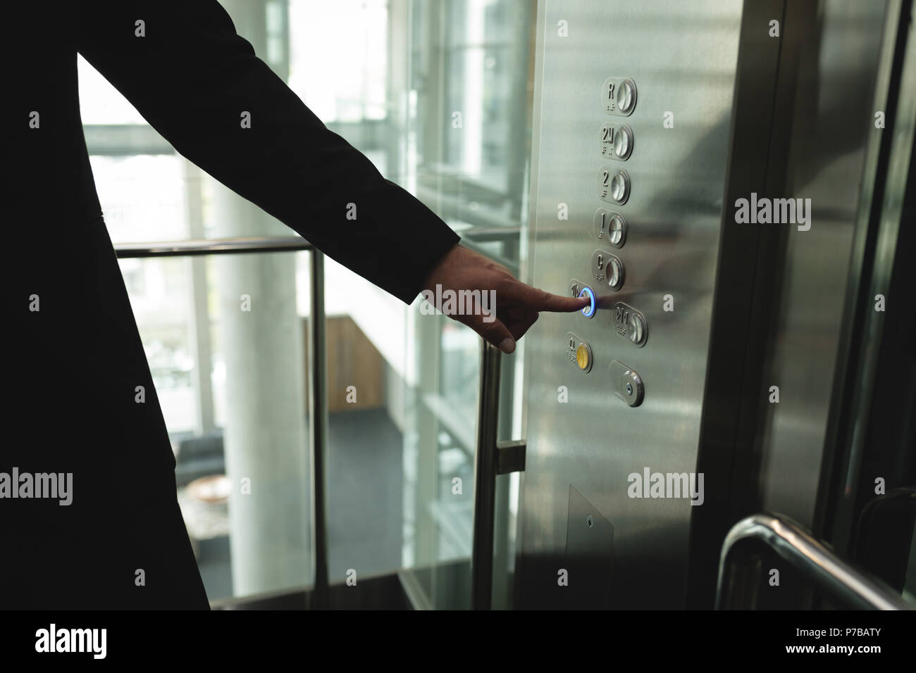 Unternehmer drücken einer Taste im Aufzug Stockfoto