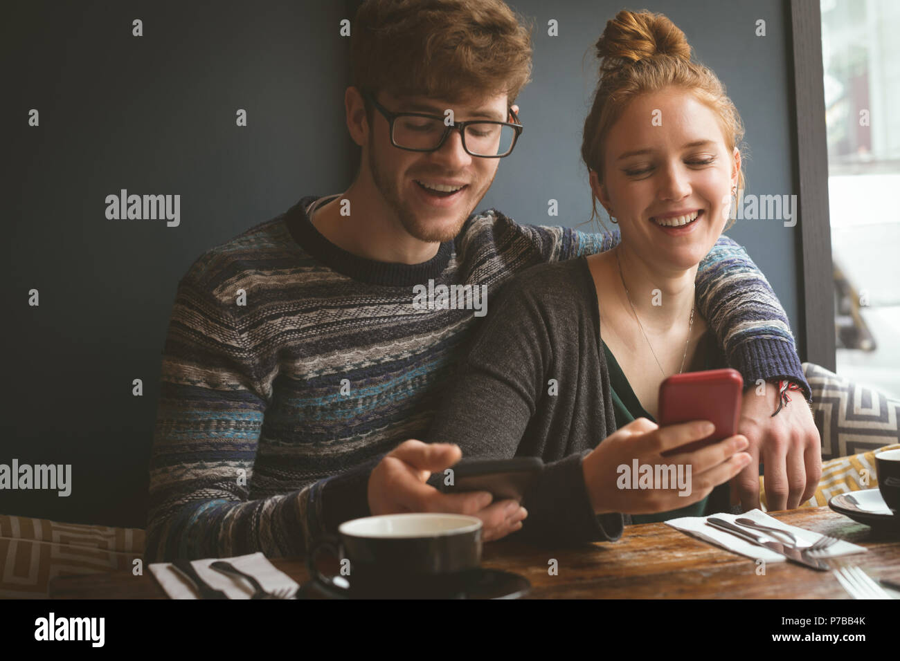 Paar mit ihren Handys im Restaurant Stockfoto
