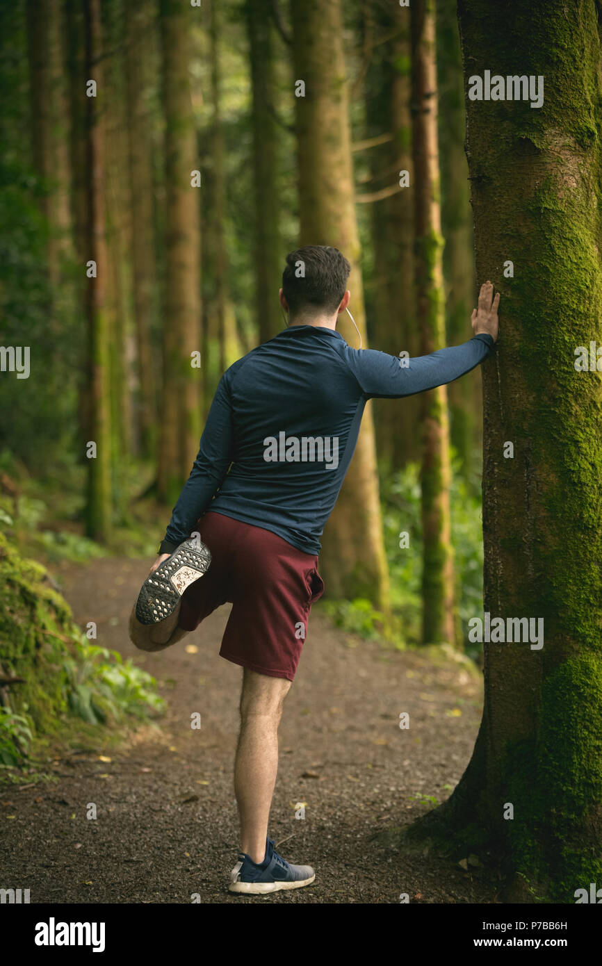 Mann zu tun stretching Übung im Wald Stockfoto