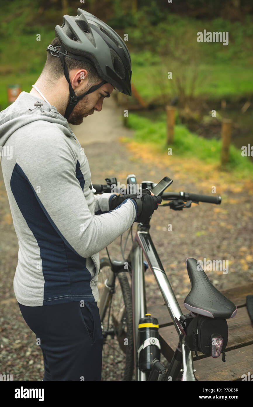 Radfahrer mit Handy im Wald Stockfoto