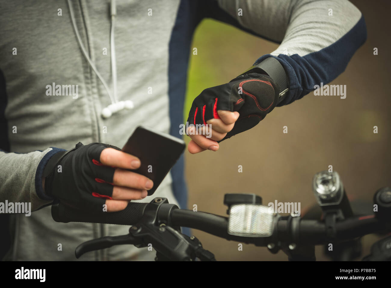 Den mittleren Abschnitt der Radfahrer Kontrolle Zeit bei der Verwendung von Mobile phone Stockfoto