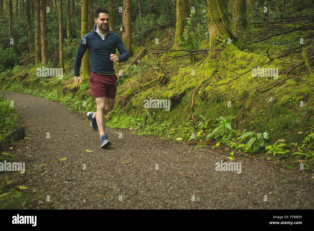 Man joggen in üppiger Wald Stockfoto
