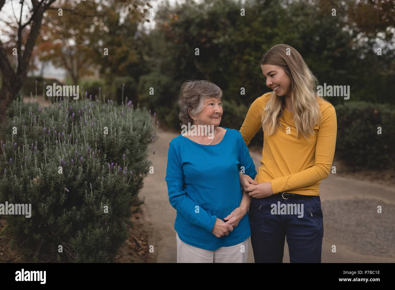 Enkelin und Oma gehen auf Asphalt Stockfoto