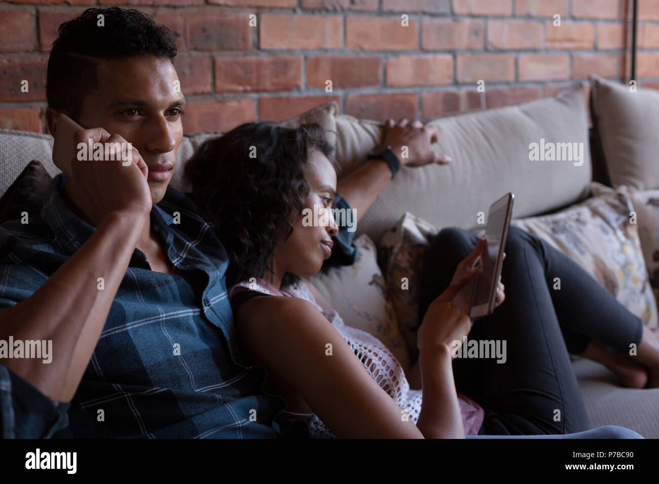 Paar mit digitalen Tablet und Gespräch am Handy Stockfoto