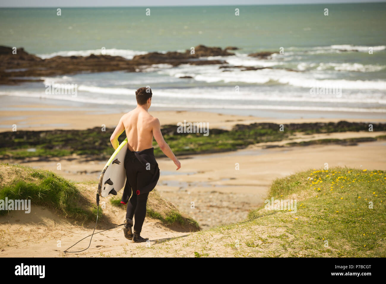 Surfer mit Surfbrett zu Fuß am Strand Stockfoto