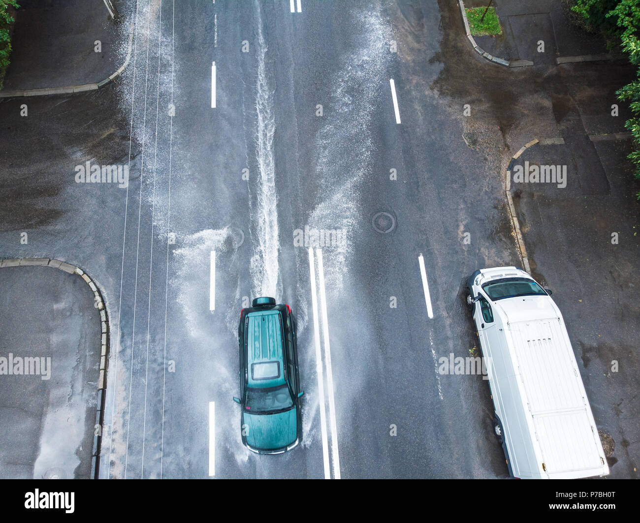 Schnelle schwarze Auto fahren auf Überflutete Straße nach starkem Regen. Luftaufnahme Stockfoto