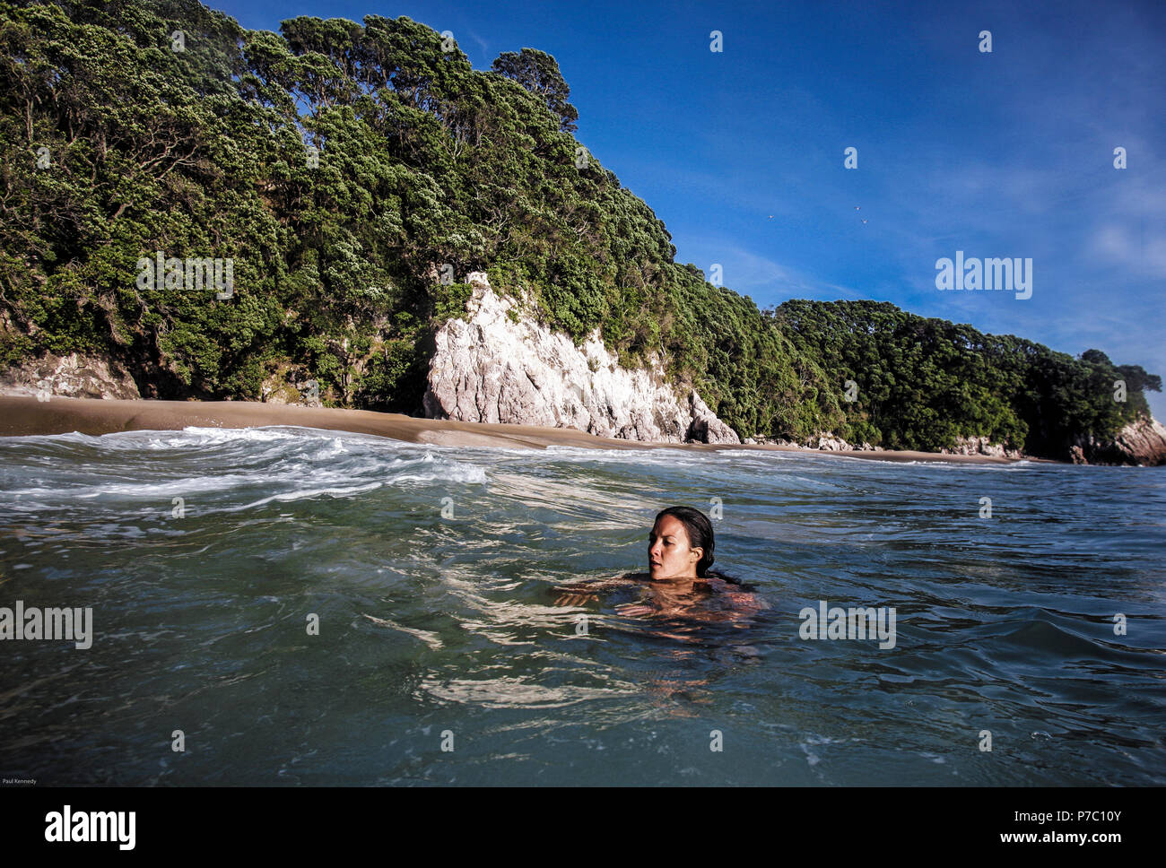 Maori Frau schwimmt im Meer am Strand in der Nähe von Whangamata, Coromandel, Neuseeland Stockfoto