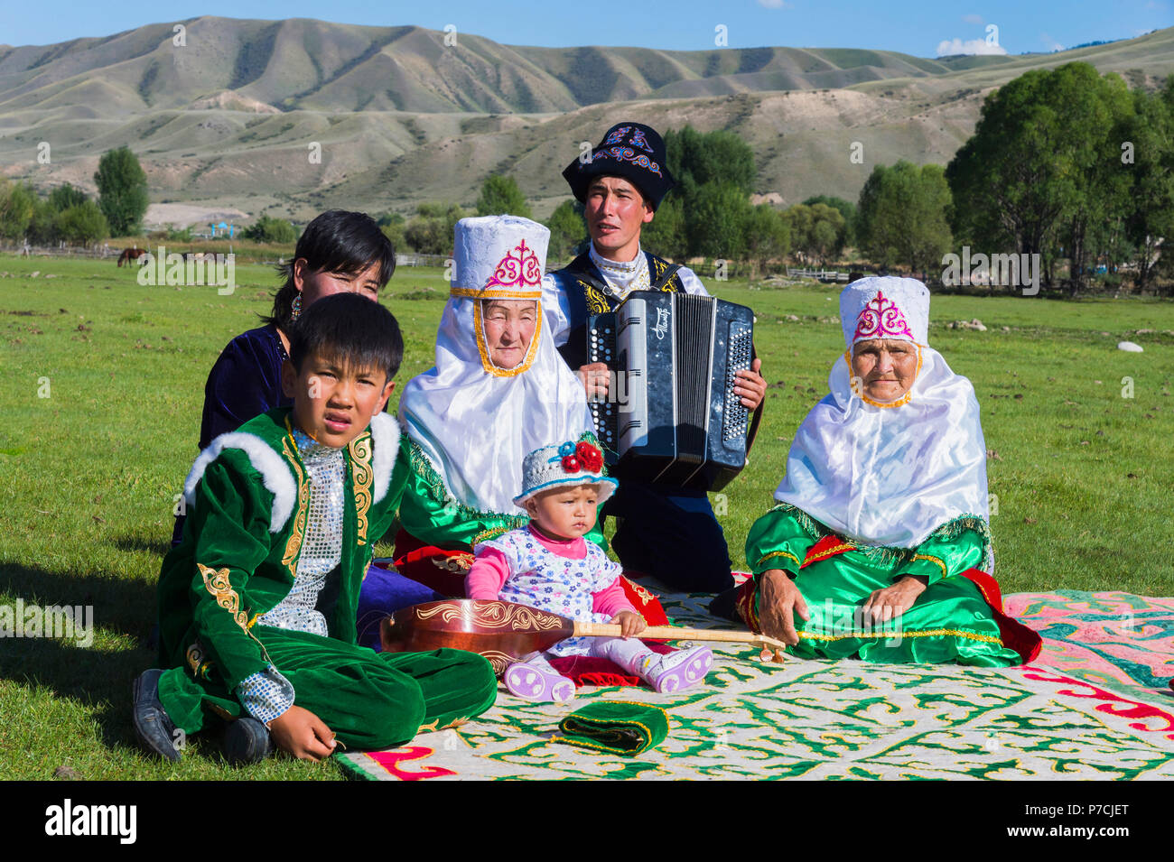 Kasachische Familie in traditioneller Kleidung, Zuhören, Akkordeon spieler, für redaktionelle nur, Sati Dorf, Tien Shan Gebirge, Kasachstan verwenden Stockfoto