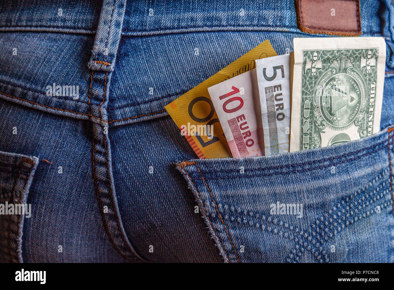 Internationale Reisen und Finanzen Konzept - USD, AUD, EUR und in der Tasche auf der Rückseite der blauen Jeans: Detailansicht Stockfoto