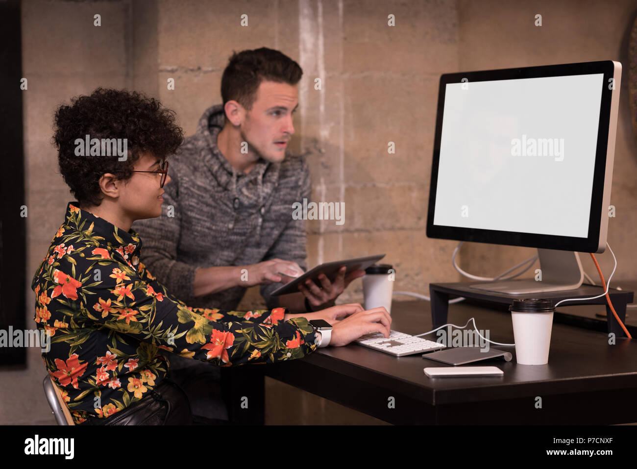 Männliche und weibliche Führungskräfte arbeiten am Computer am Schreibtisch Stockfoto