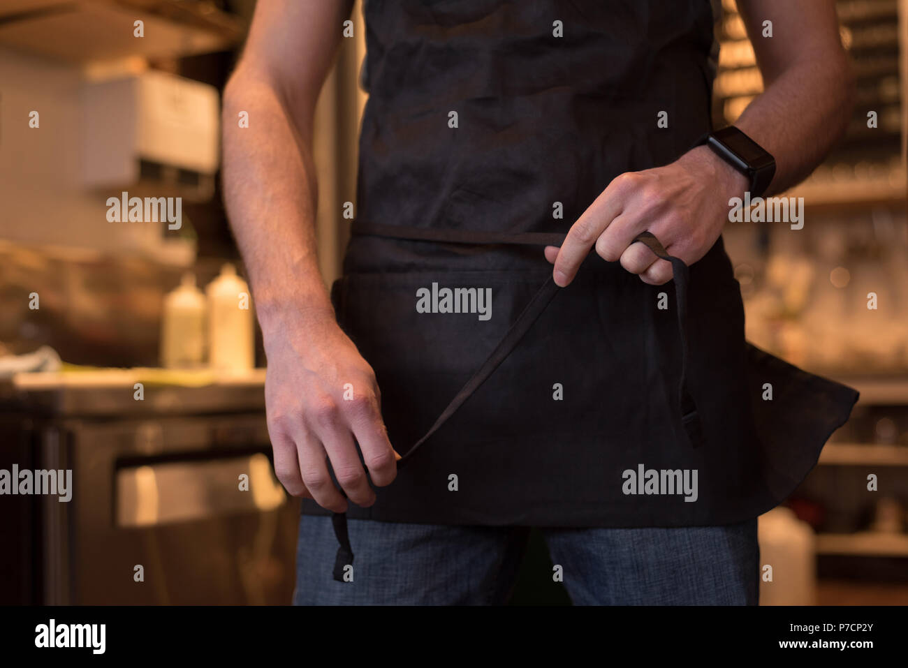 Männliche Kellner tragen Schürze im Cafe Stockfoto