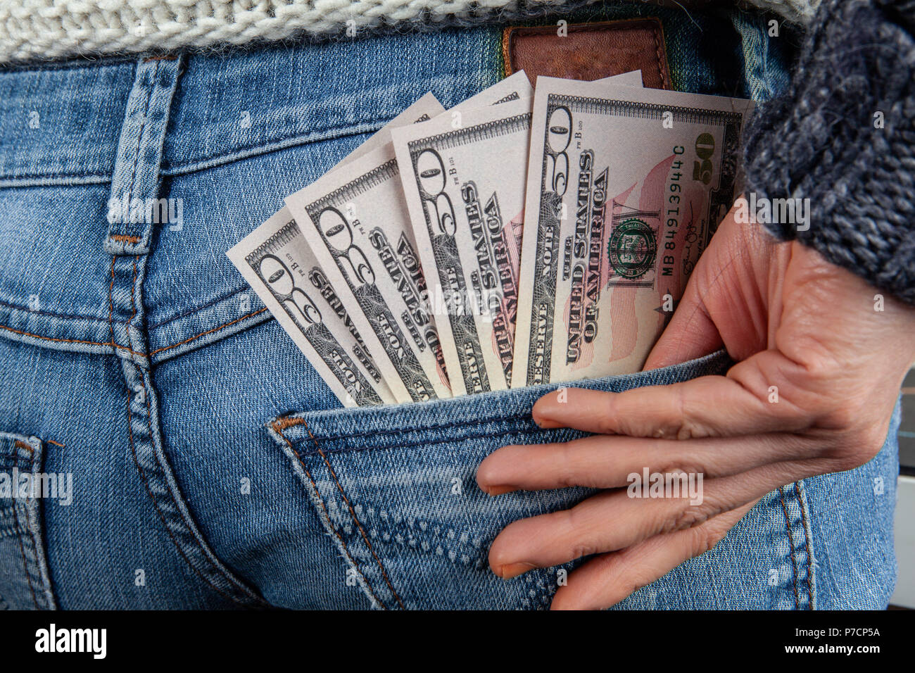Mindestlohn Konzept-US 50-Dollarscheine in der gesässtasche der Jeans mit weiblichen Hand Stockfoto