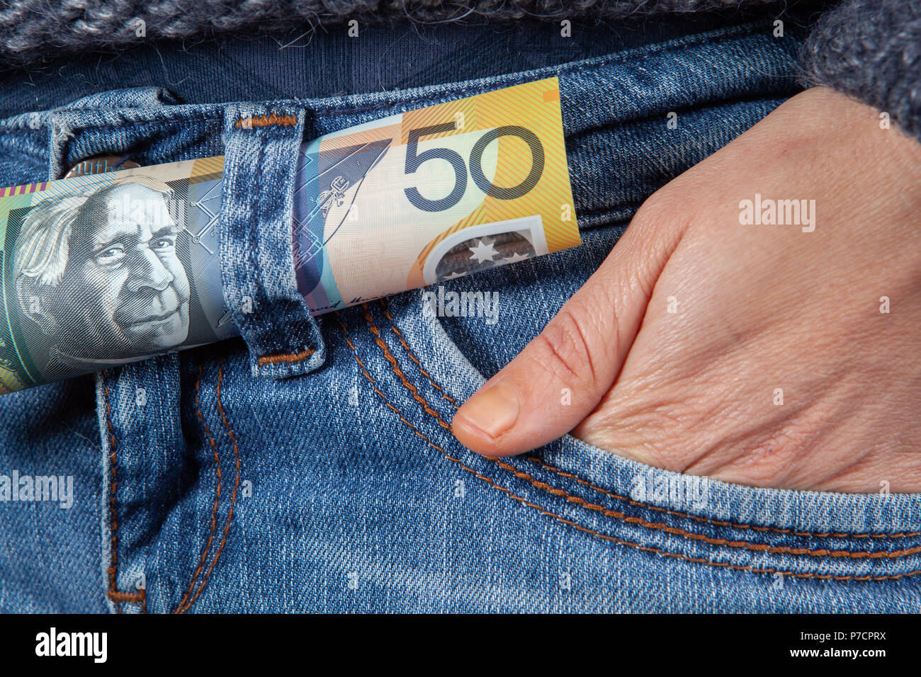 50 australische Dollar Bill und weibliche Hand in der Tasche auf der Vorderseite der blauen Jeans closeup Stockfoto