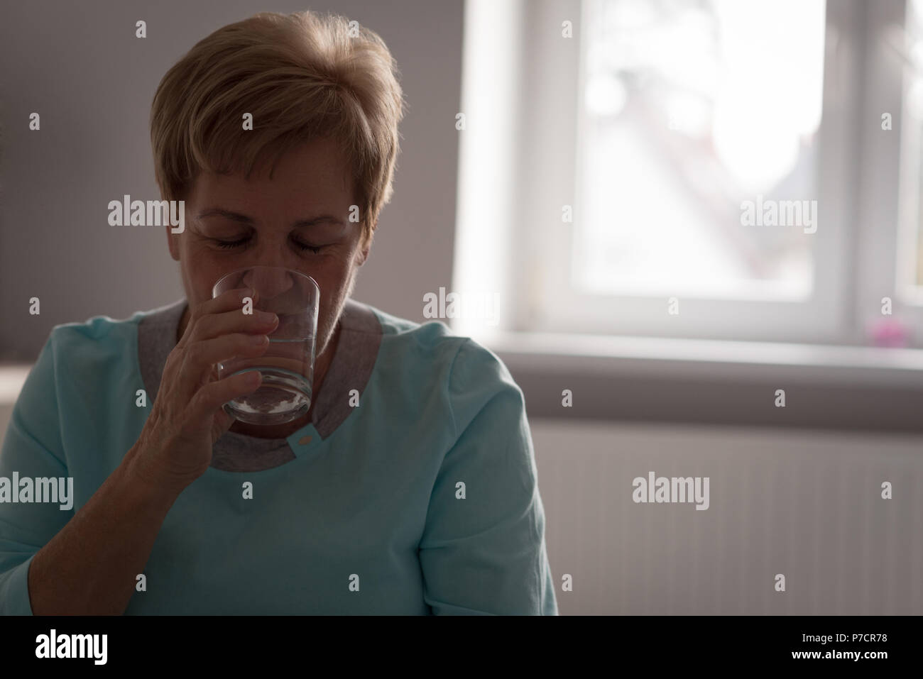 Ältere Frau mit Glas Wasser Stockfoto