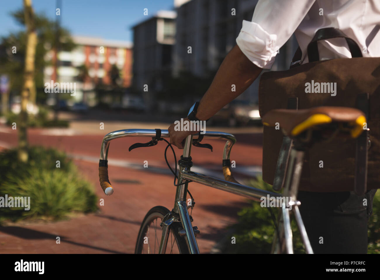 Geschäftsmann mit seinem Fahrrad an Büroflächen Stockfoto