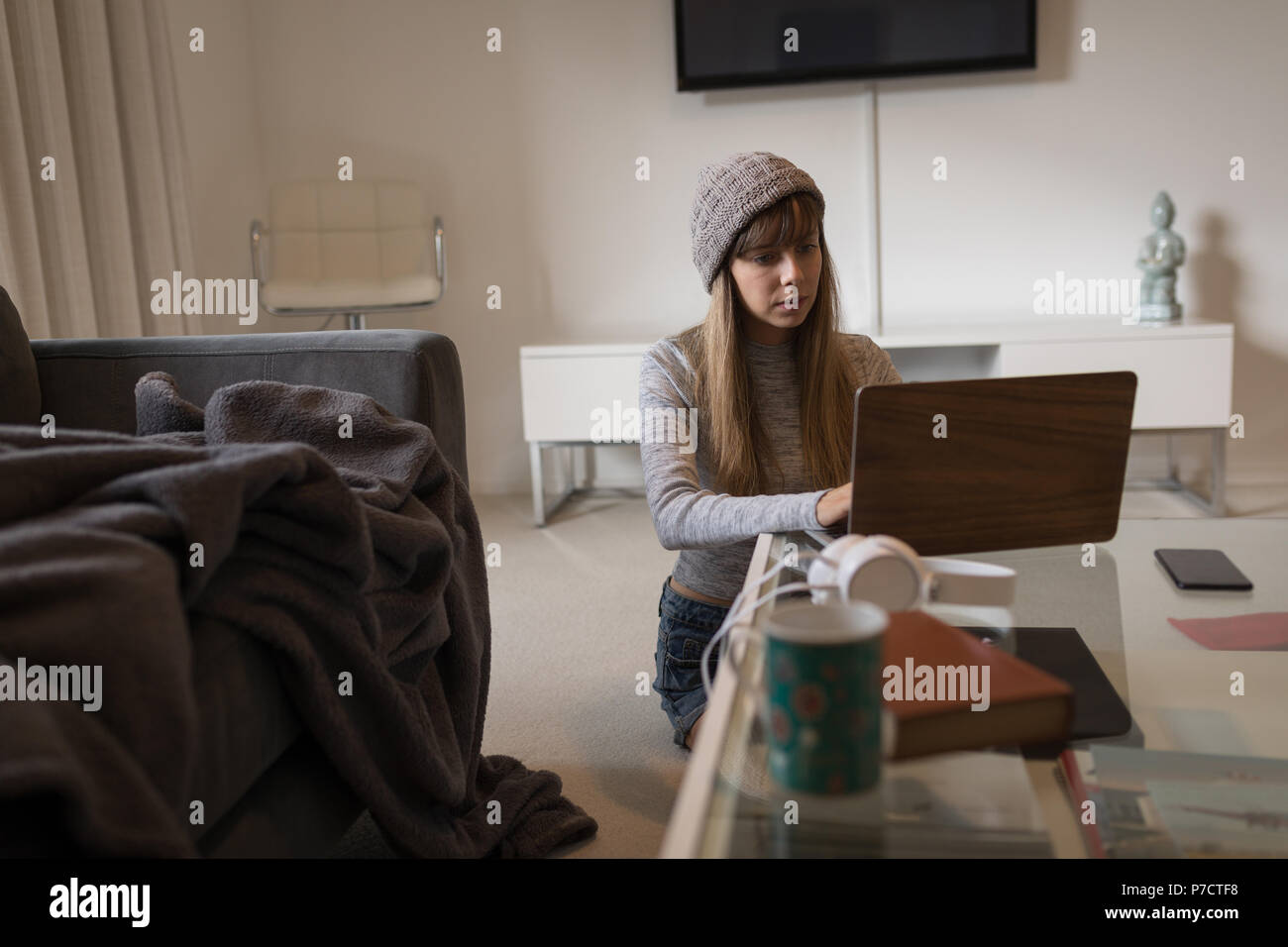 Frau mit Laptop im Wohnzimmer Stockfoto