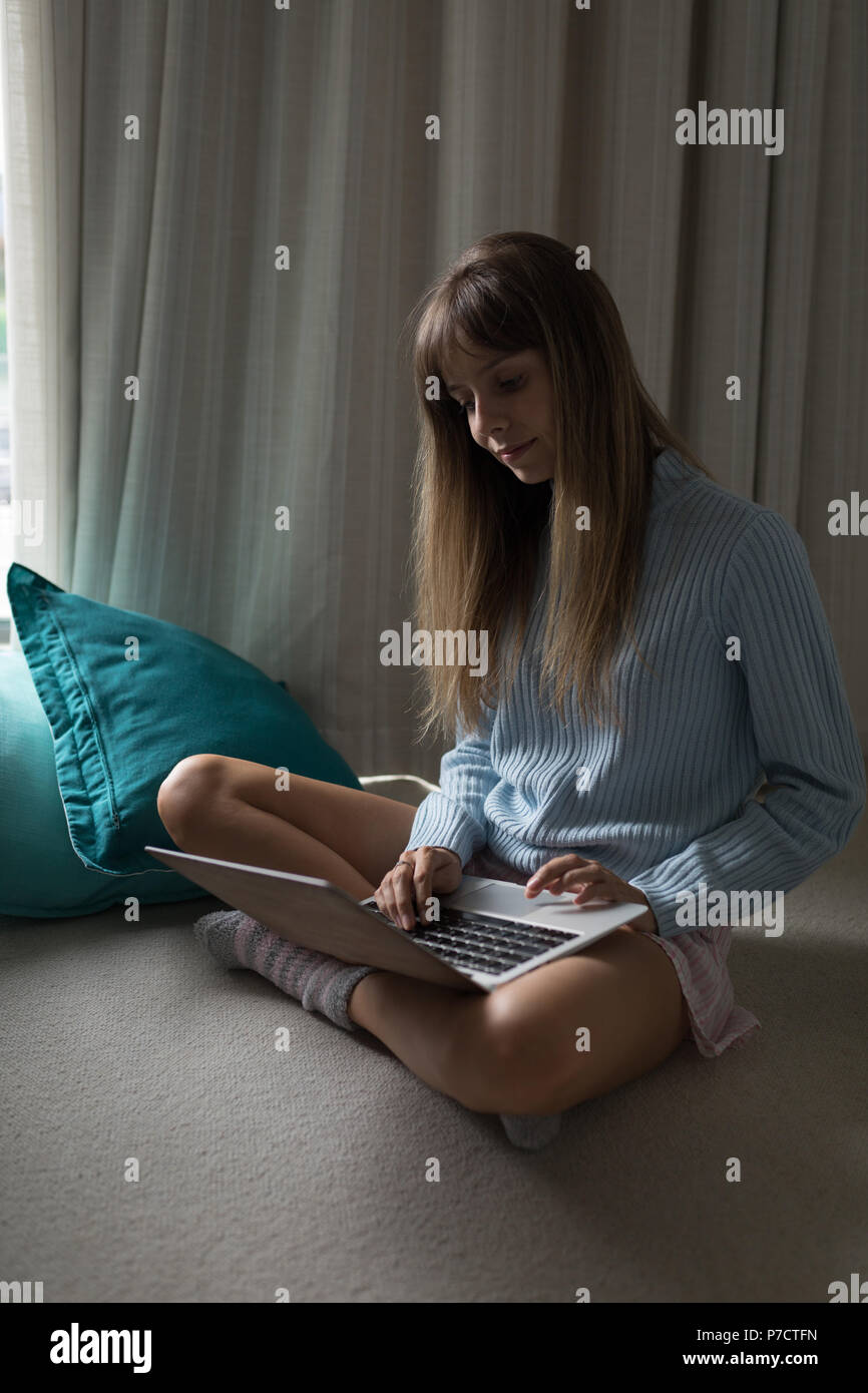 Frau mit Laptop zu Hause Stockfoto