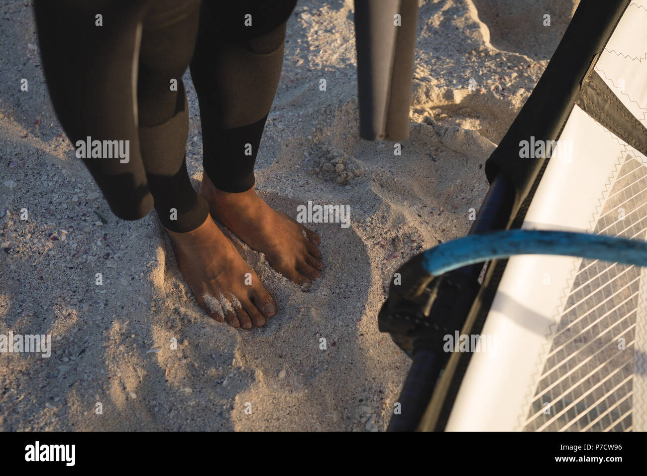 Männliche surfer stehend mit Drachen am Strand Stockfoto