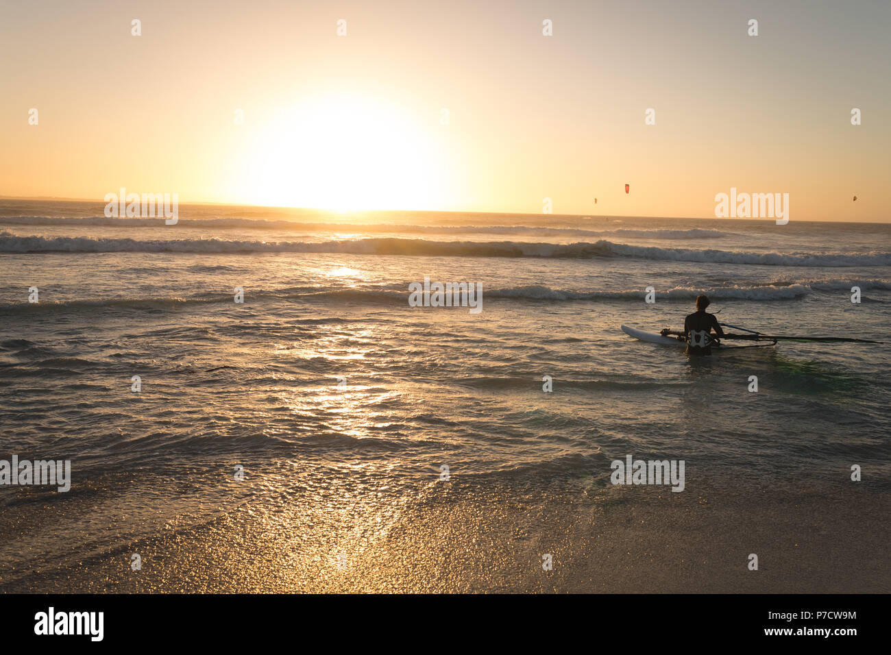 Männliche Surfer surfen mit Surfbrett im Meer Stockfoto