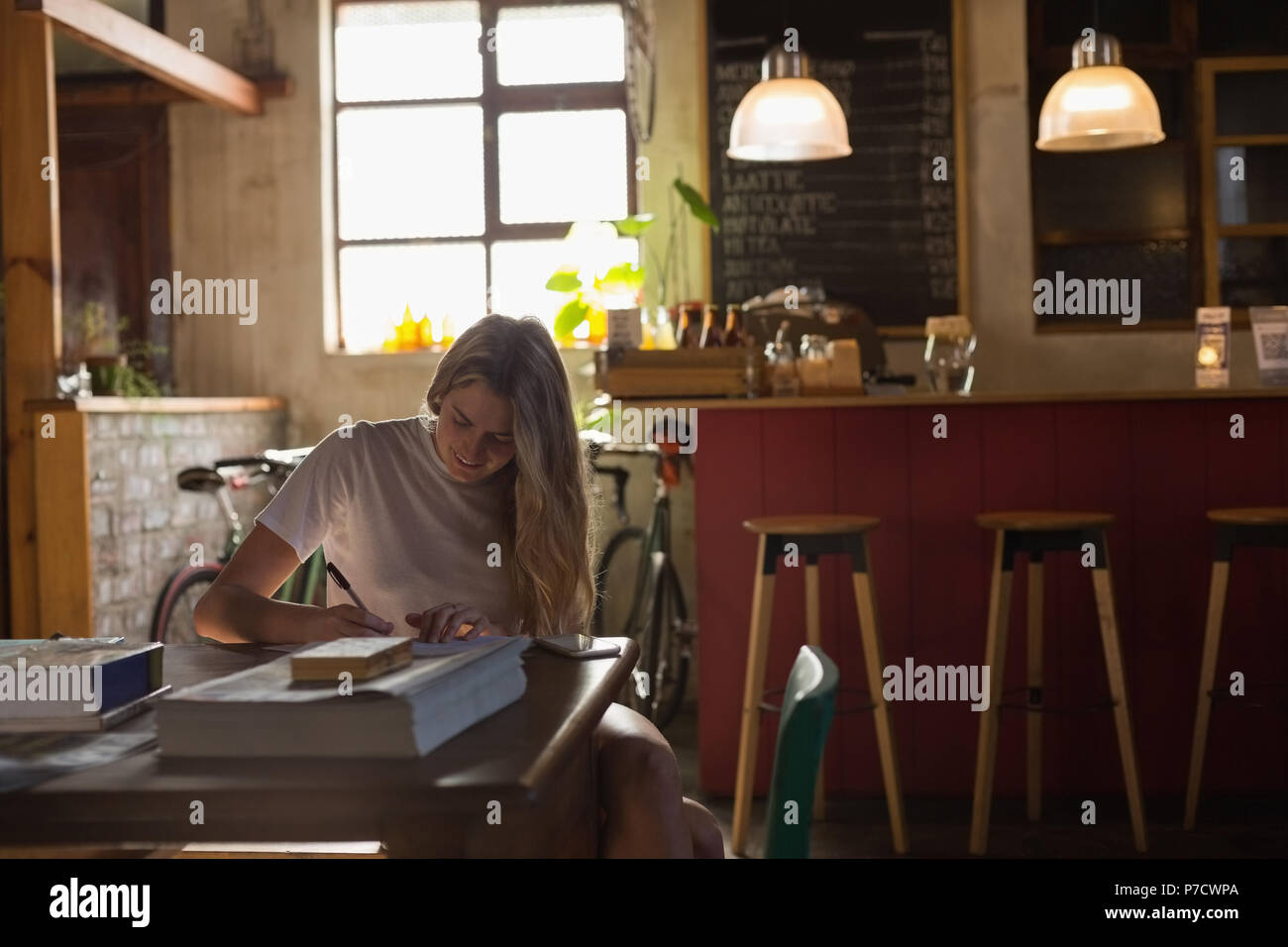 Frau schreiben auf ein Buch im Cafe Stockfoto