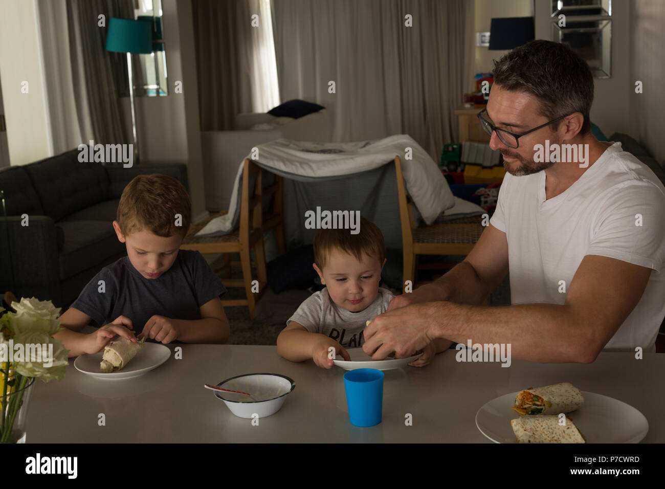 Vater und Sohn beim Frühstück auf einem Esstisch Stockfoto