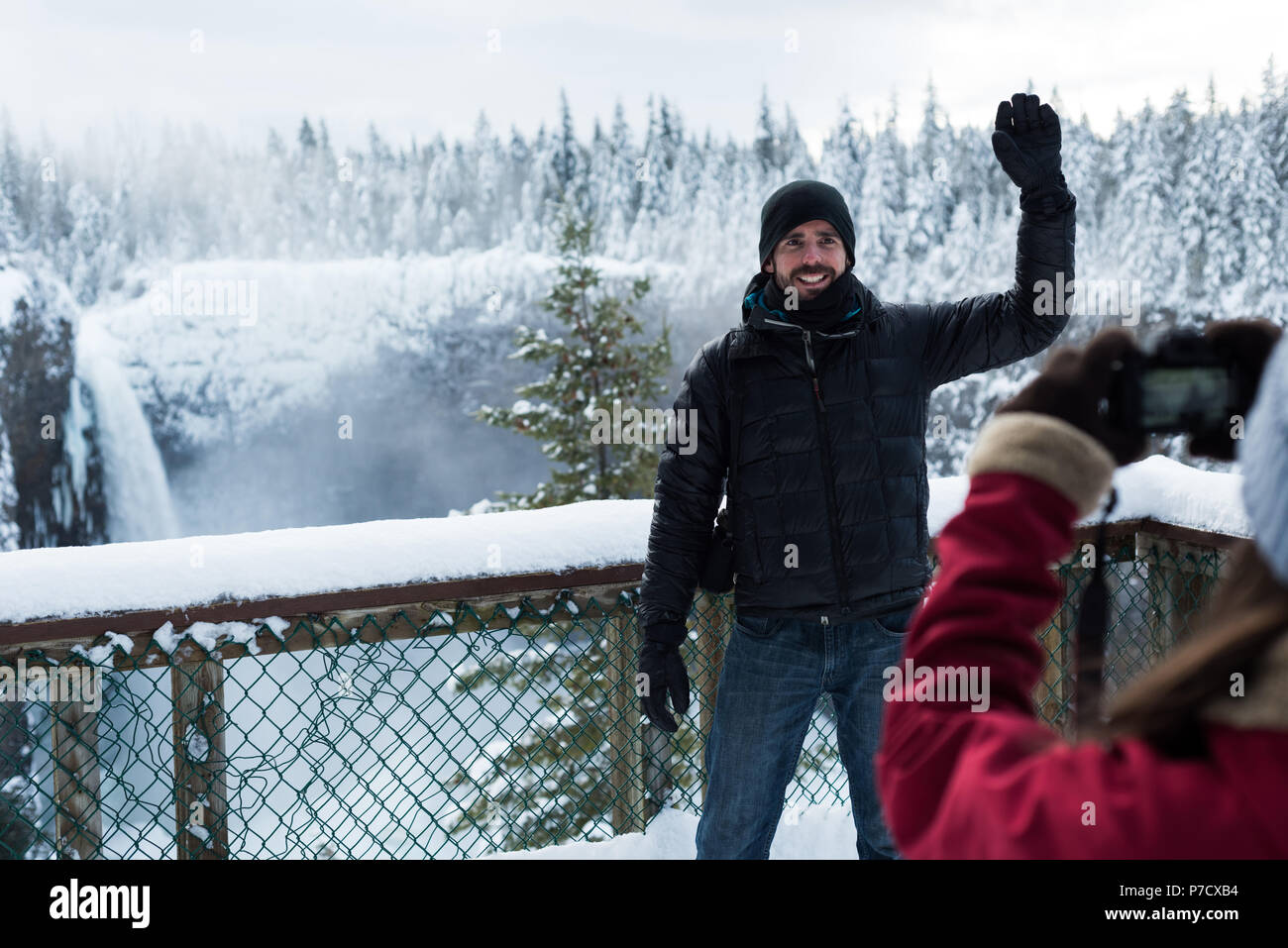 Frau unter Foto von Mann mit Kamera Stockfoto