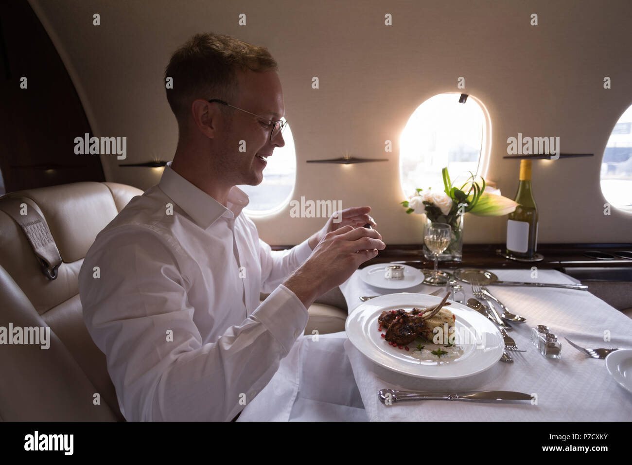 Geschäftsmann unter Foto von Essen mit Handy Stockfoto