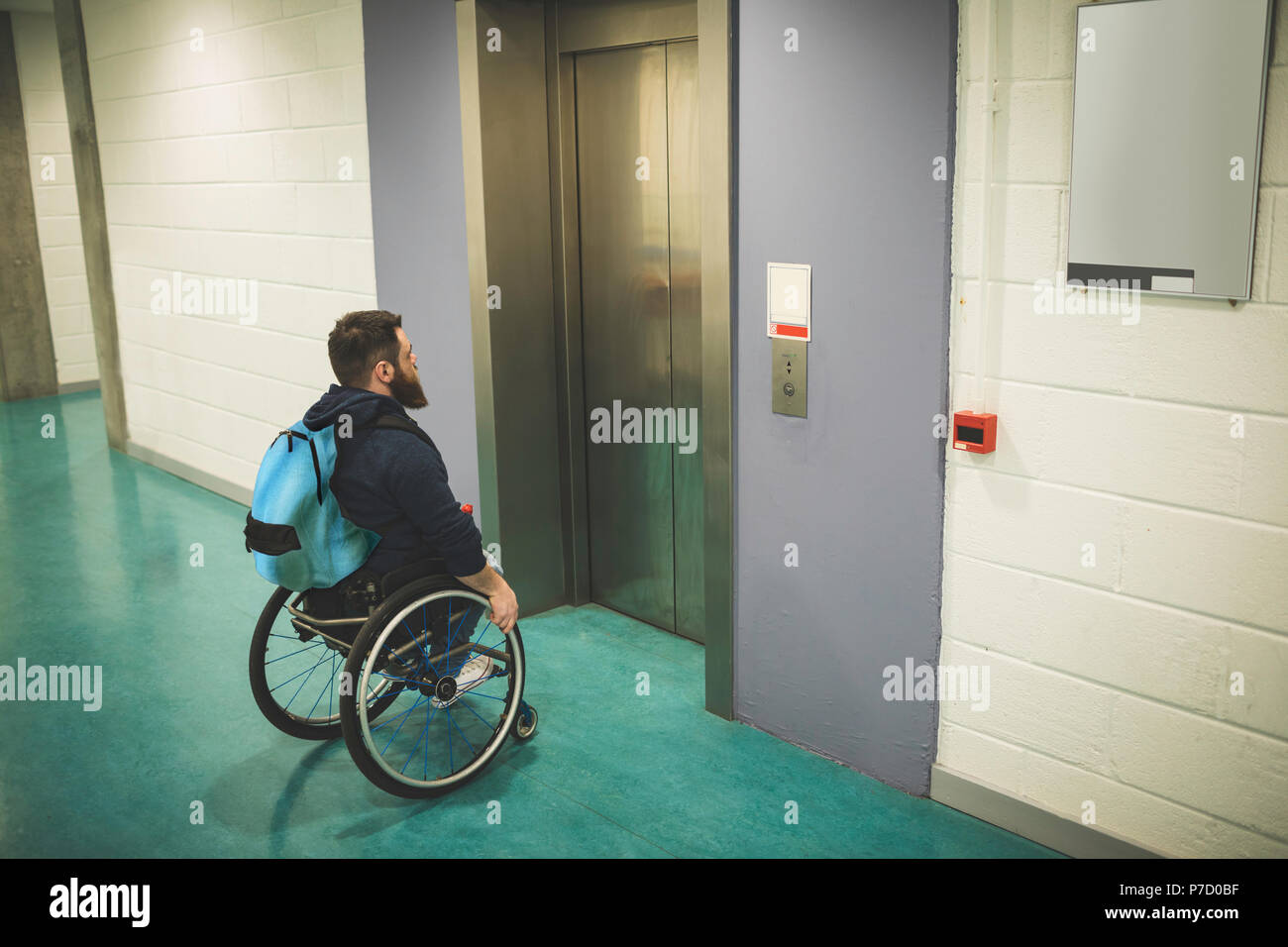 Behinderte Menschen im Rollstuhl auf den Fahrstuhl warten Stockfoto
