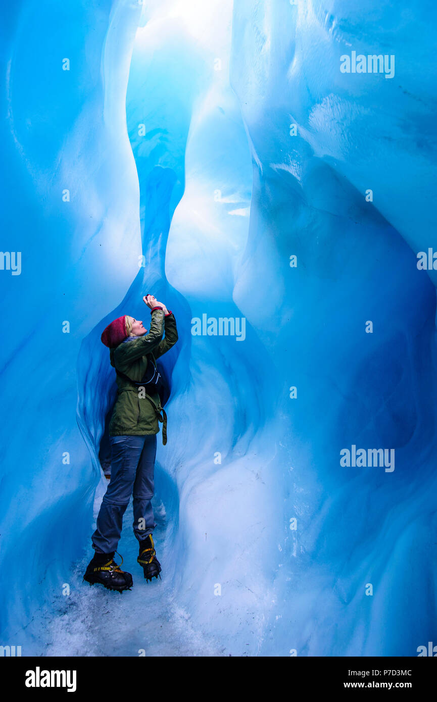 Frau fotografieren in einer Eishöhle in Fox Glacier, South Island, Neuseeland Stockfoto