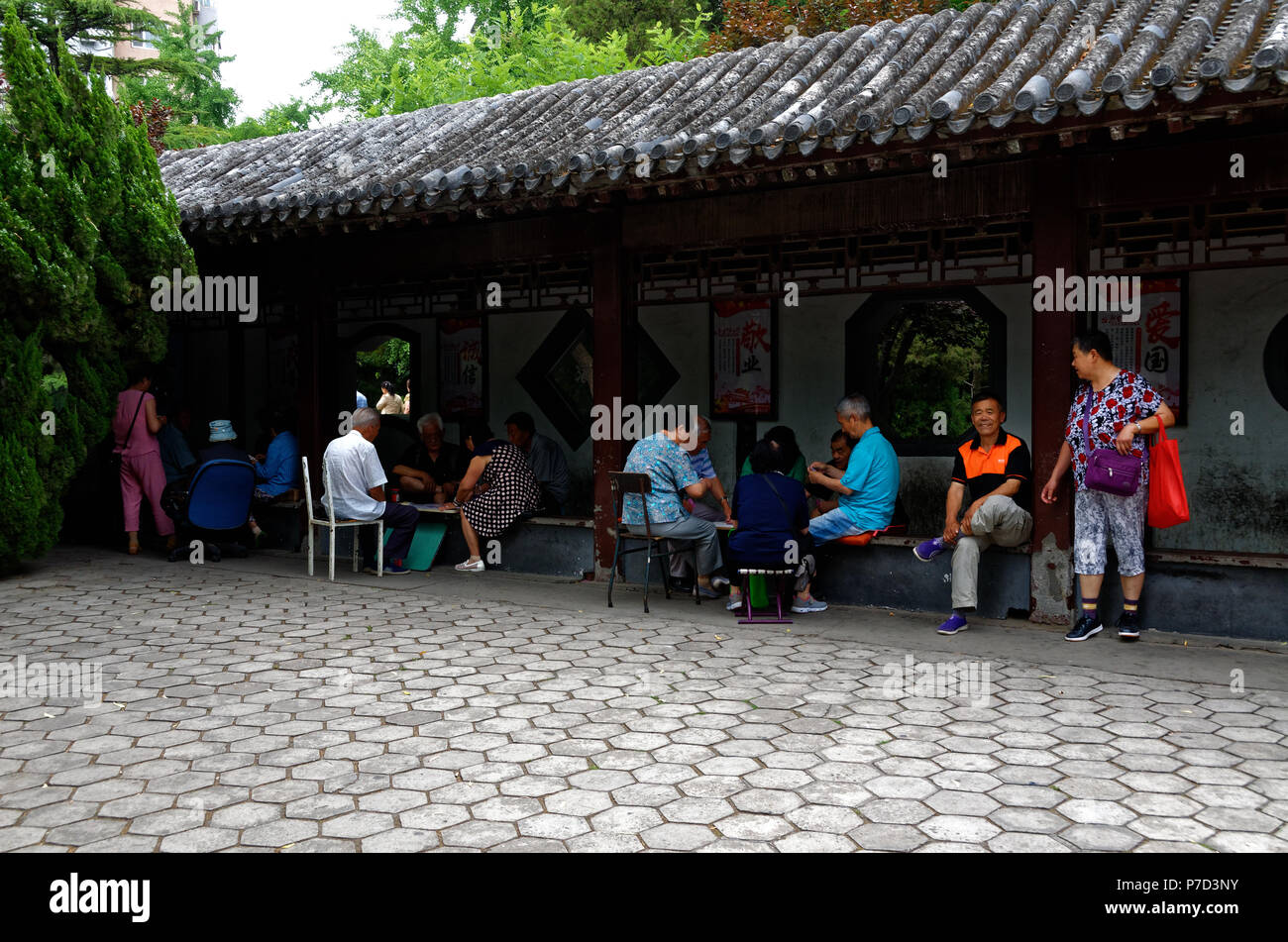 Soziale Aktivitäten, einschließlich Karten, Brettspiele und Angeln in den langen Flur und Lakeside in Tuanjiehu Park, Peking, China Stockfoto