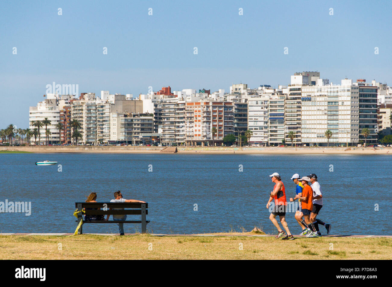 Jogger und Menschen auf einer Bank an der Rambla, Promenade von Montevideo, Uruguay Stockfoto