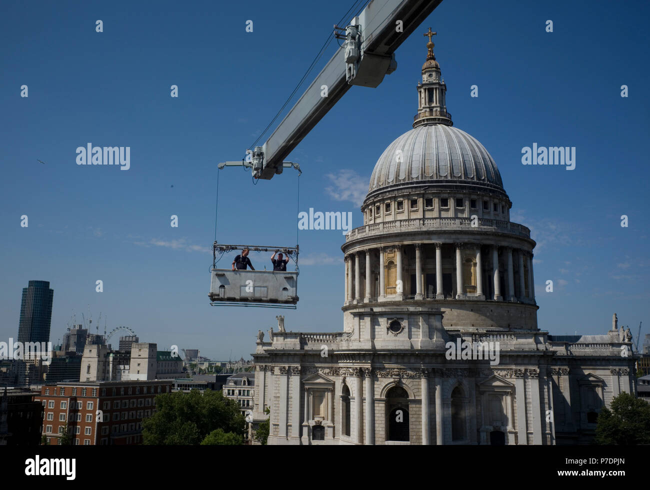 Fenster Reiniger sind in einer Wiege vor einem Bürogebäude neben der St. Paul's Cathedral in London, Großbritannien, 3. Juli 2018 ausgesetzt. Stockfoto